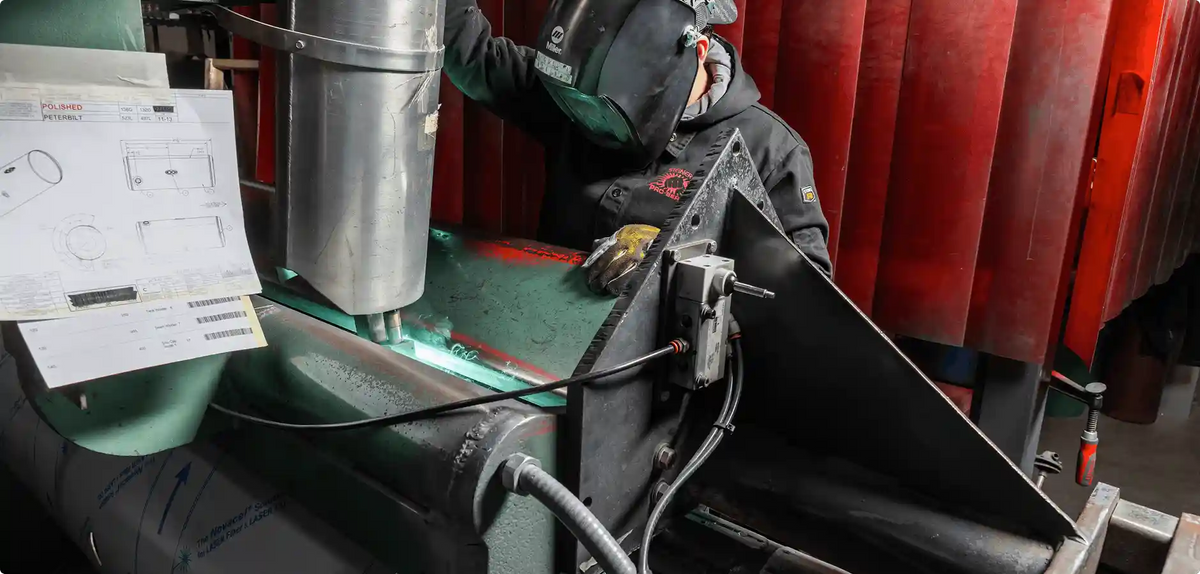 Person working on a machine with a red curtain in the background