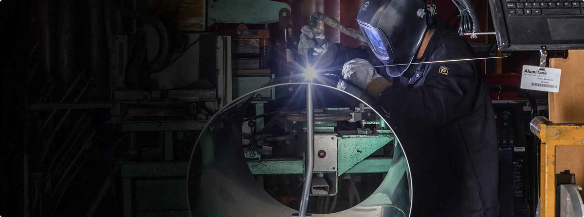 Person welding in a workshop with protective gear