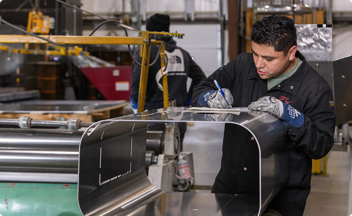 Worker measuring aluminum panel component for aviation industry