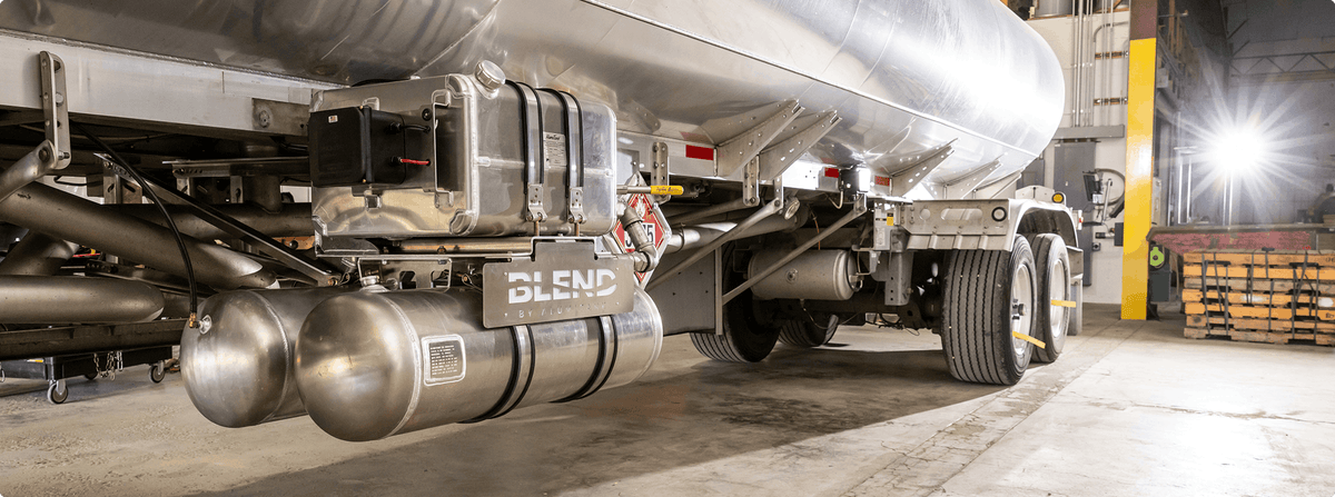 Close-up of a trailer with cylindrical tanks and 'Blend' branding in an industrial setting.
