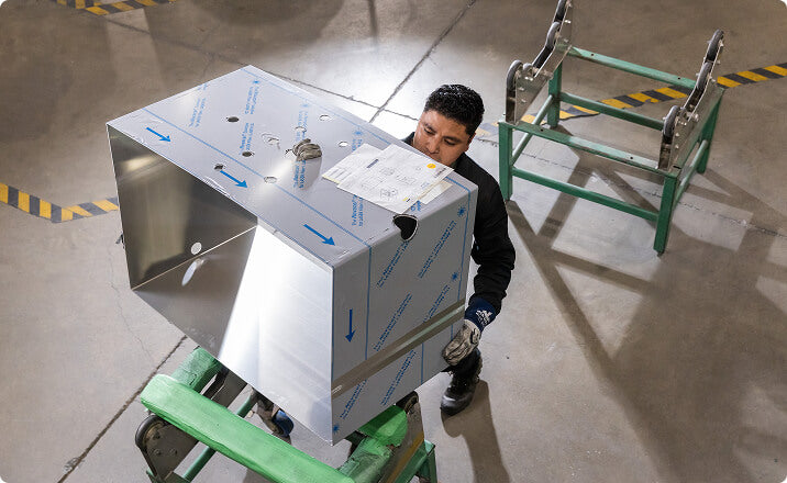 Worker handling aluminum container for environmental services industry