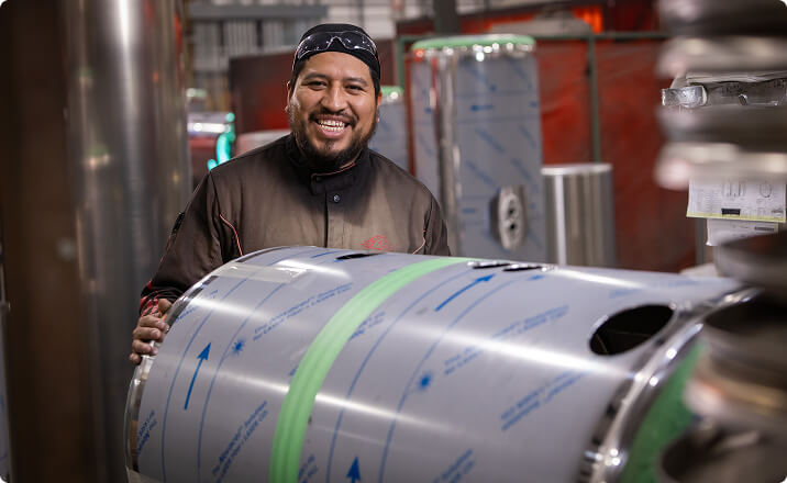 Worker handling aluminum tank for heavy duty towing industry