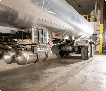 Large tanker truck with 'BLEND' branding inside a warehouse.