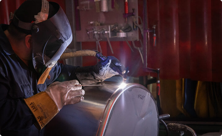 Welder fabricating aluminum tank for telecom industry