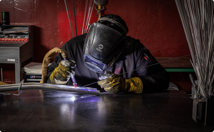 Welder fabricating aluminum components for utilities industry